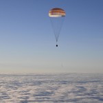 La capsula Soyuz, attaccata a un paracadute, trasporta tre astronauti della Stazione Spaziale Internazionale pronti a toccare Terra dopo cinque mesi e mezzo