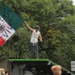 Un manifestante sventola la bandiera messicana