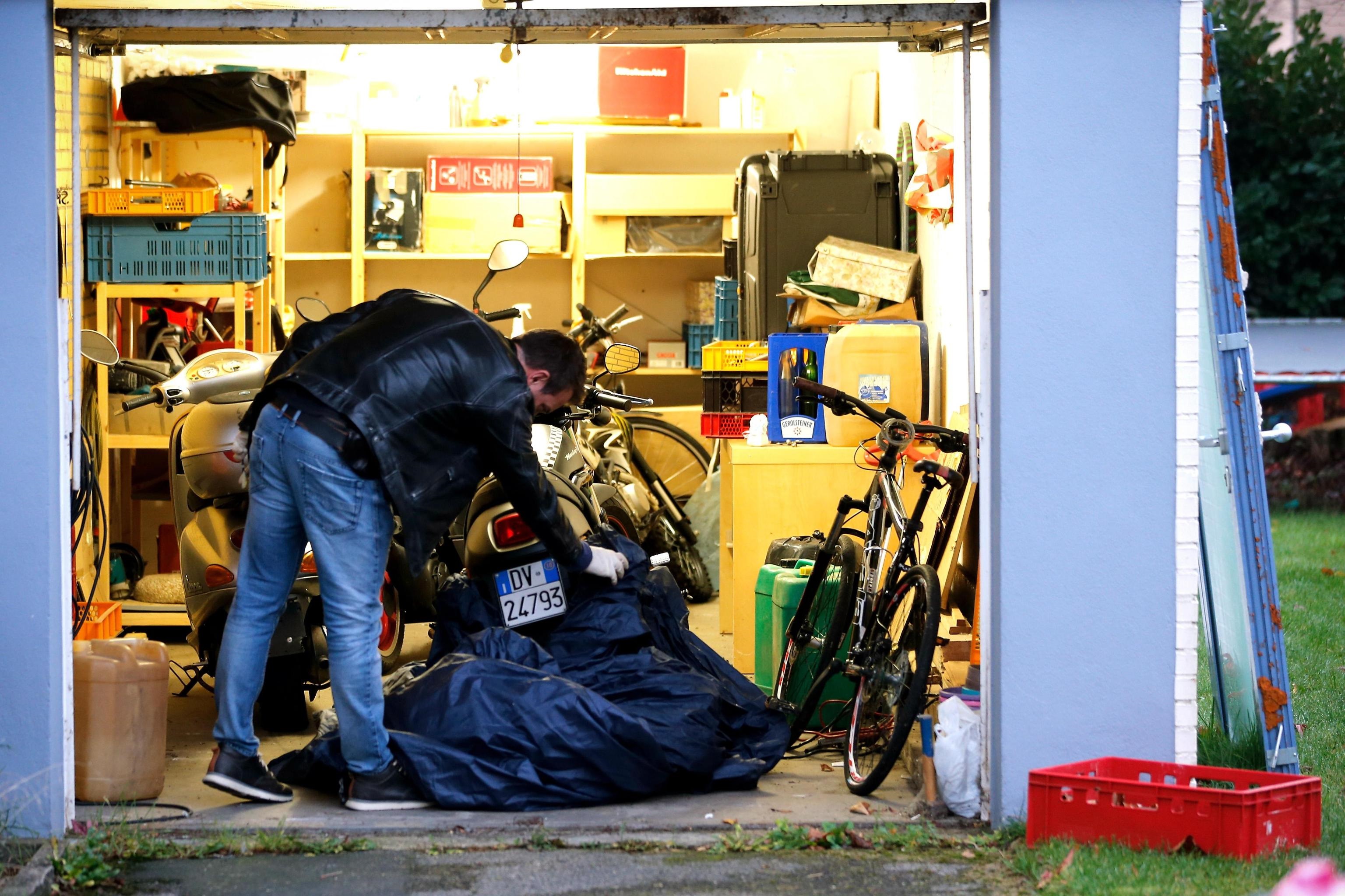 Un poliziotto svolge la perquisizione all'interno di un garage