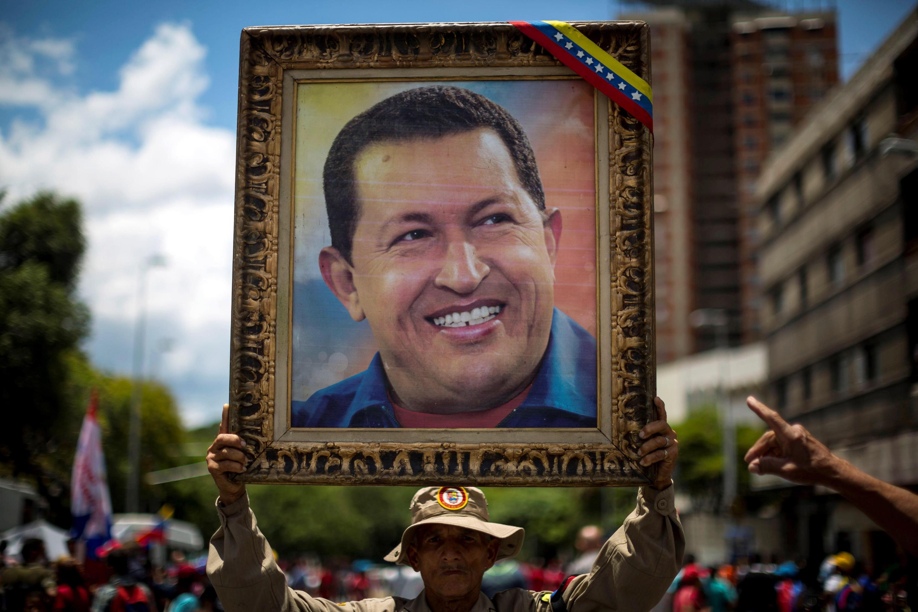 Alcuni manifestanti espongono il ritratto di Hugo Chavez, presidente del Venezuela e guida del movimento populista dal 1999 fino alla sua morte nel 2013 Alcuni manifestanti espongono il ritratto di Hugo Chavez, presidente del Venezuela e guida del movimento populista dal 1999 fino alla sua morte nel 2013