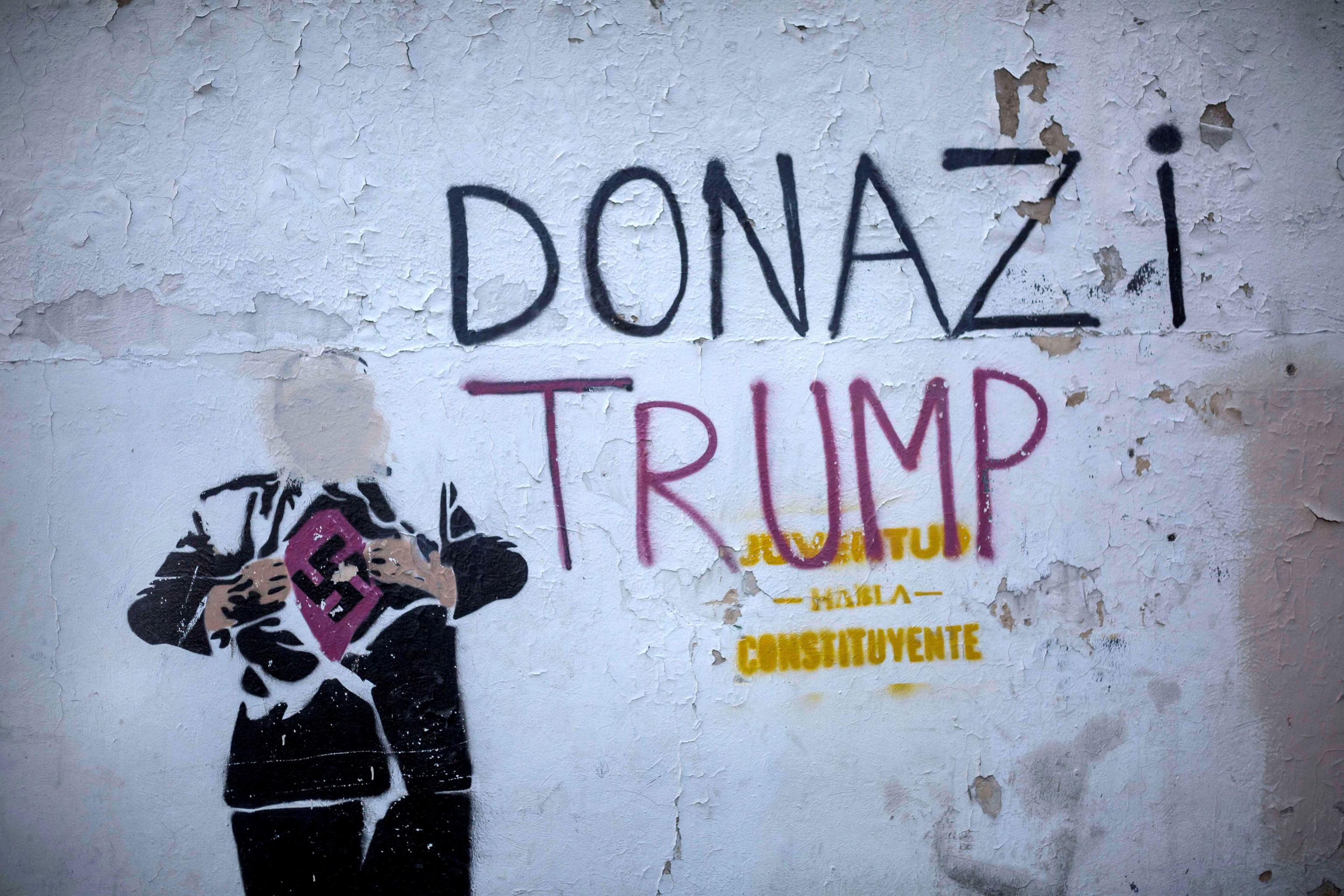 Nel murales il presidente degli Stati Uniti mostra una svastica sotto la giacca. Per l'occasione è stato ribattezzato "Donazi" Trump Nel murales il presidente degli Stati Uniti mostra una svastica sotto la giacca. Per l'occasione è stato ribattezzato "Donazi" Trump