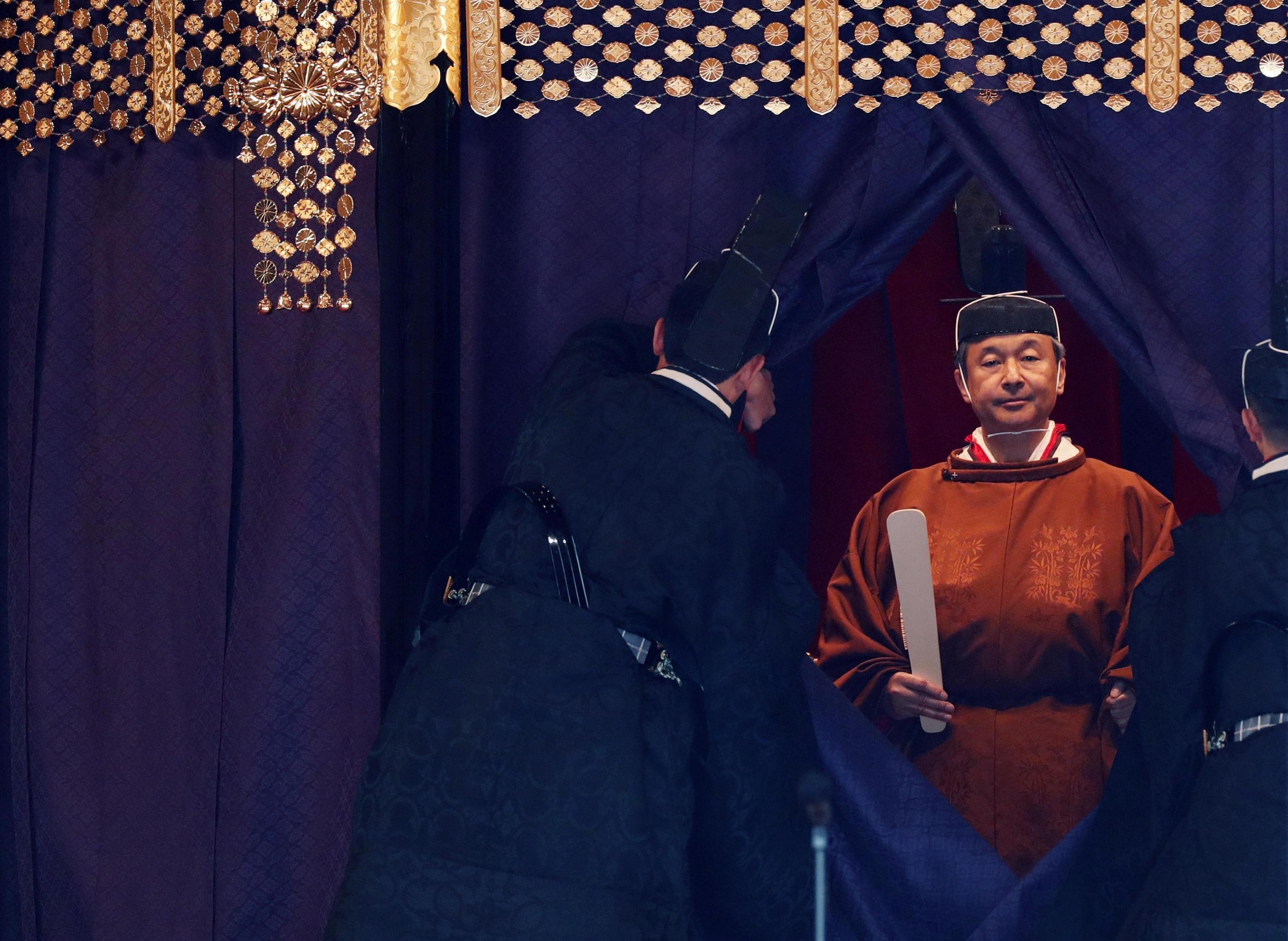 Naruhito, vestito nei rituali paramenti color arancione scuro, ha proclamato ufficialmente la propria ascesa al trono