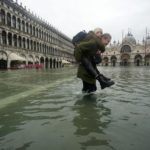 Due ragazze camminano nell'acqua alta in piazza San Marco