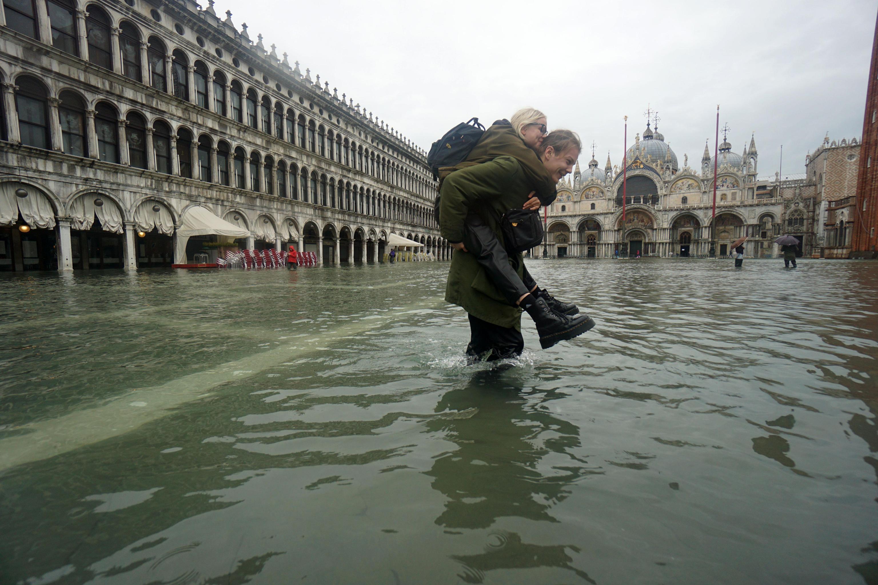 Due ragazze camminano nell'acqua alta in piazza San Marco