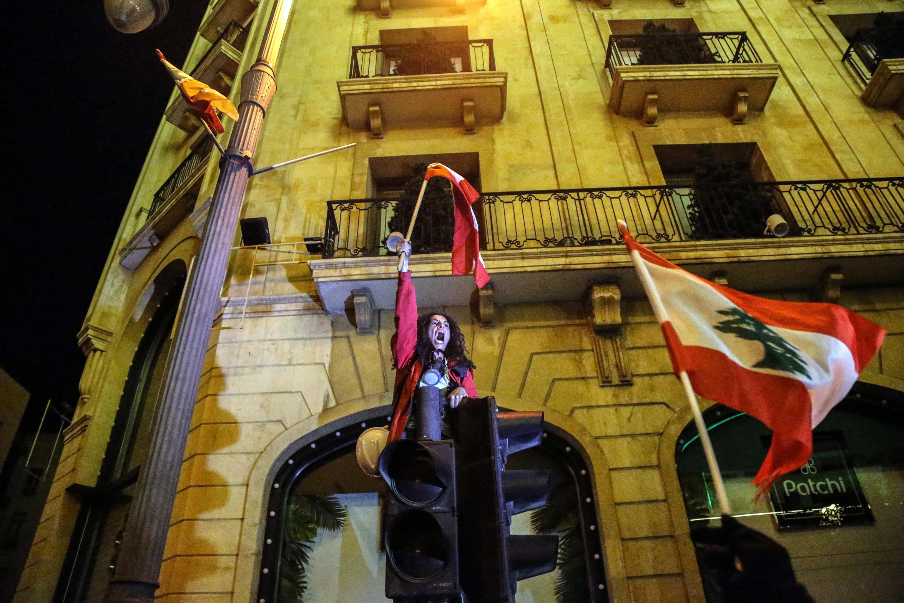 Una manifestante sventola la bandiera del Libano per le strade di Beirut