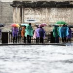 Allerta meteo anche a Roma. Alcuni turisti si riparano dalla pioggia in Campidoglio