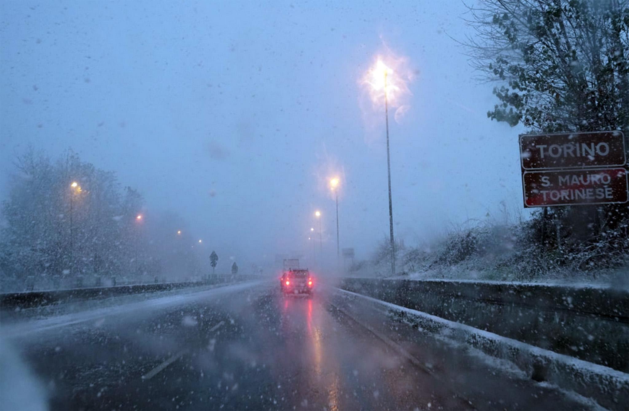 Una strada di Torino dove c'è scarsa visibilità a causa della neve mista a pioggia