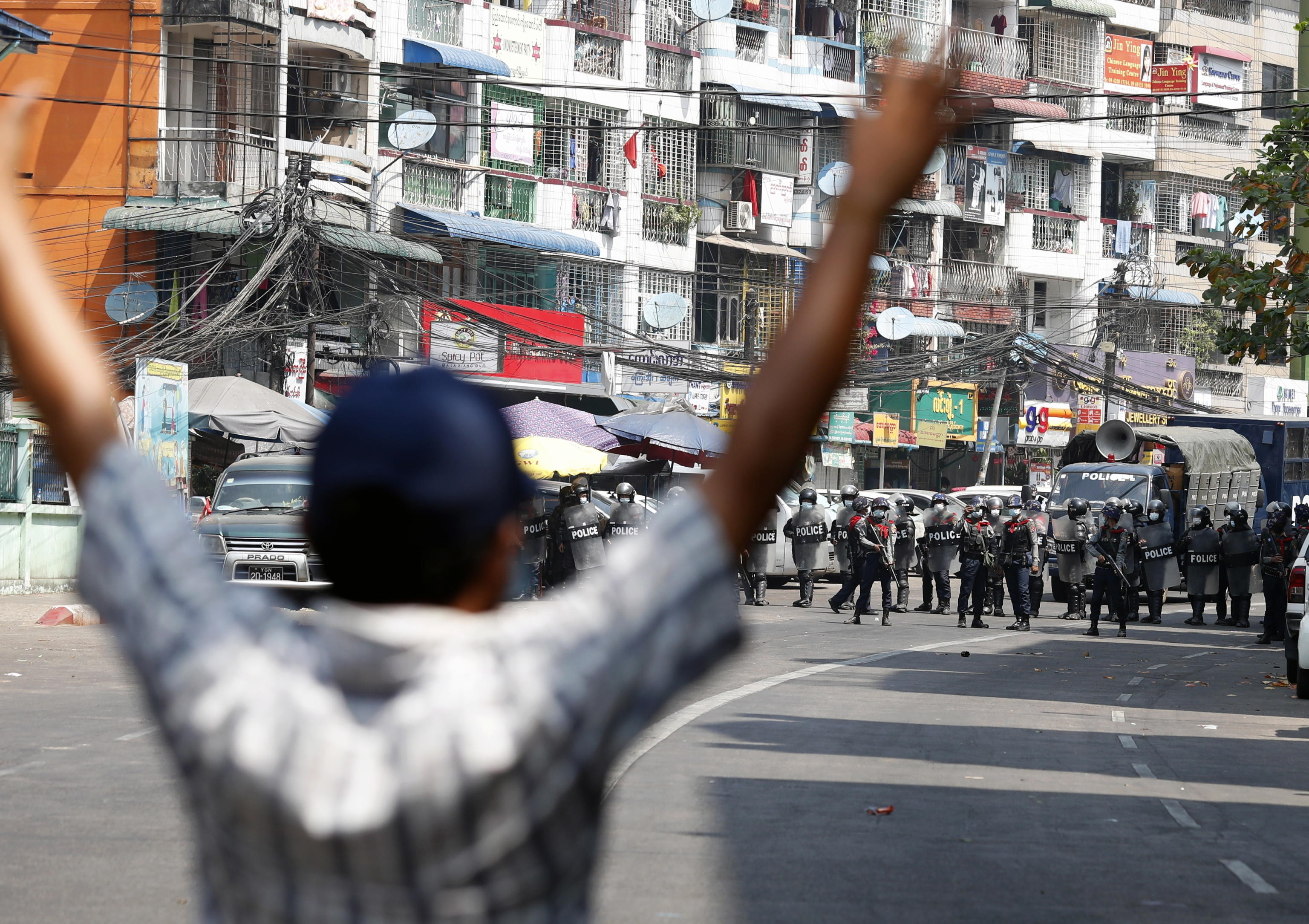 Un manifestante reagisce mentre gli agenti di polizia anti-sommossa bloccano una strada durante una protesta contro il colpo di stato militare, a Yangon, Myanmar, 26 febbraio 2021.