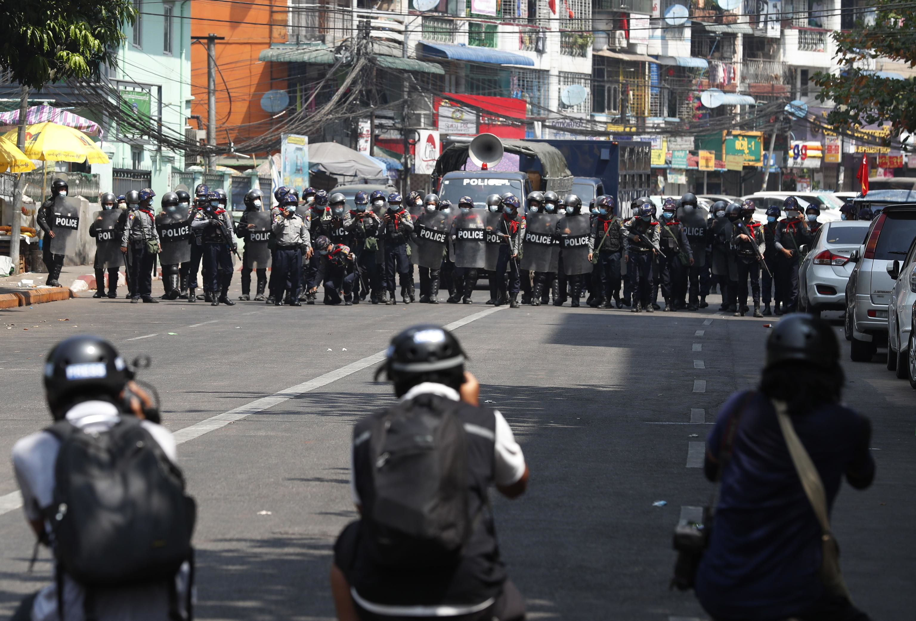 La polizia antisommossa avanza in una strada mentre i membri della stampa scattano foto durante una protesta contro il colpo di stato militare, a Yangon, Myanmar, 26 febbraio 2021.