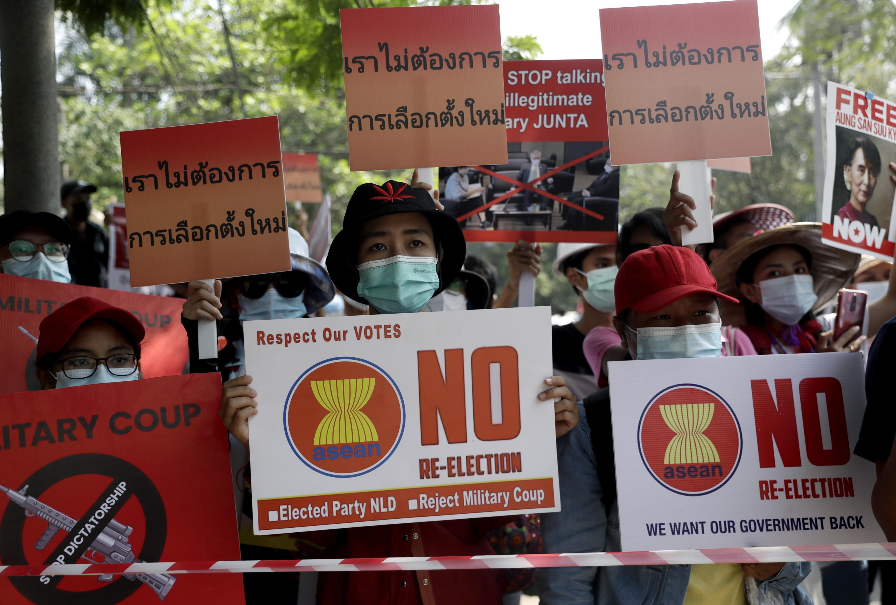 I manifestanti tengono cartelli con la scritta "Non abbiamo bisogno della rielezione" durante una protesta contro il colpo di stato militare, vicino all'Ambasciata di Thailandia a Yangon, Myanmar, il 26 febbraio 2021.