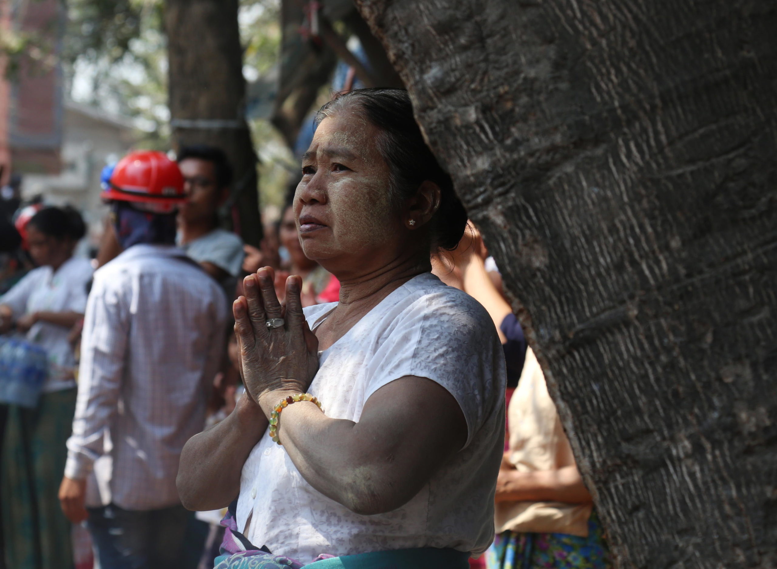Una donna prega a Yangon durante le proteste