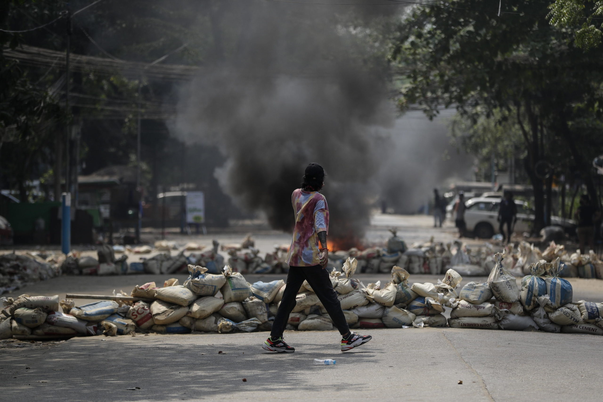 Un ragazzo cammina tra le barricate durante gli scontri a Yangon