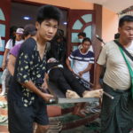Il corpo di un ragazzo ucciso viene portato via durante gli scontri a Mandalay