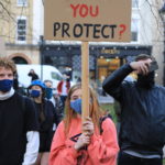 Frasi polemiche su cartelli e striscioni, su questo la scritta "Chi state proteggendo?"
