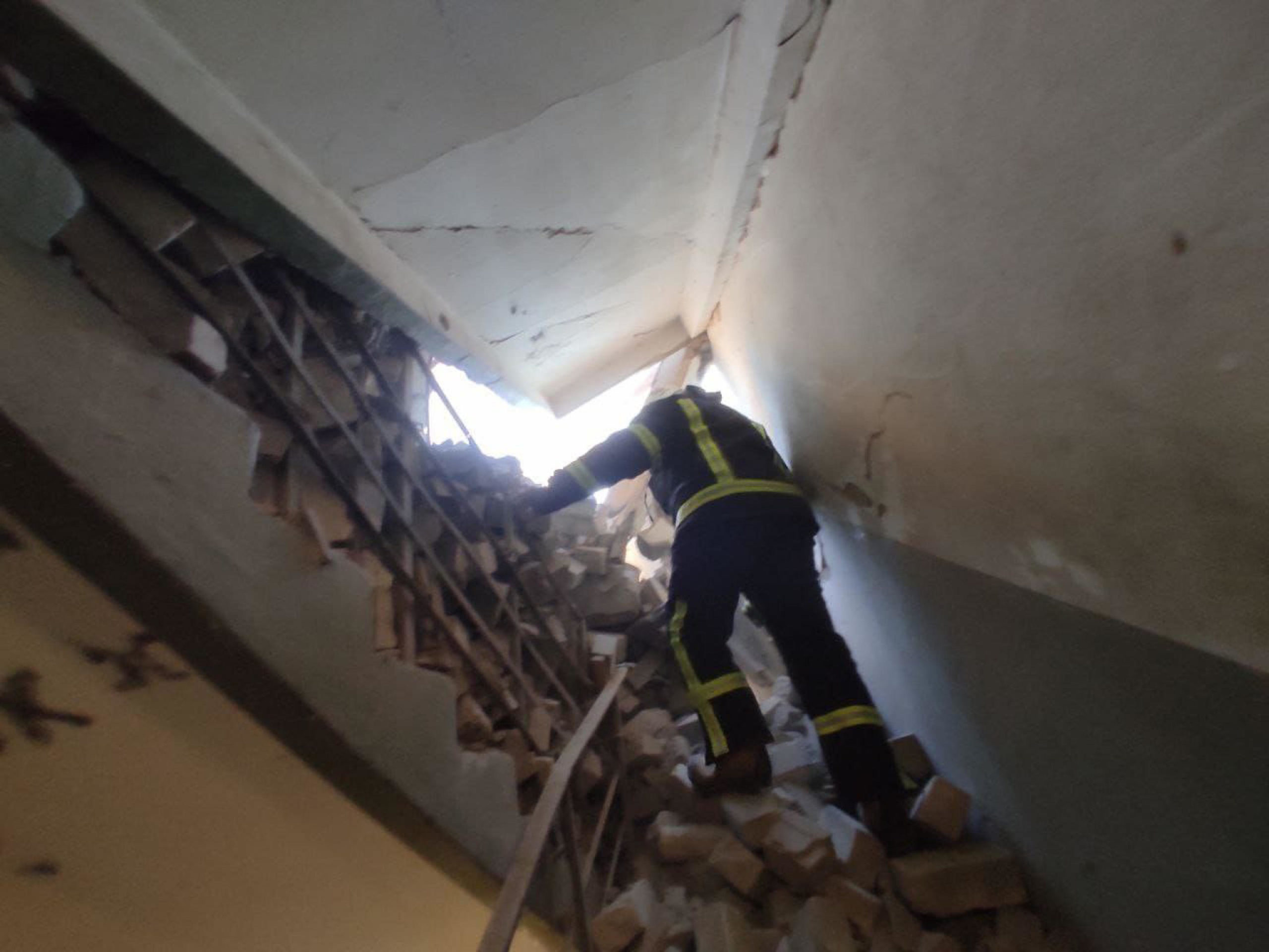 Un soccorritore nell'edificio residenziale colpito dai bombardamenti nel distretto di Shevchenkivskyi a Kiev