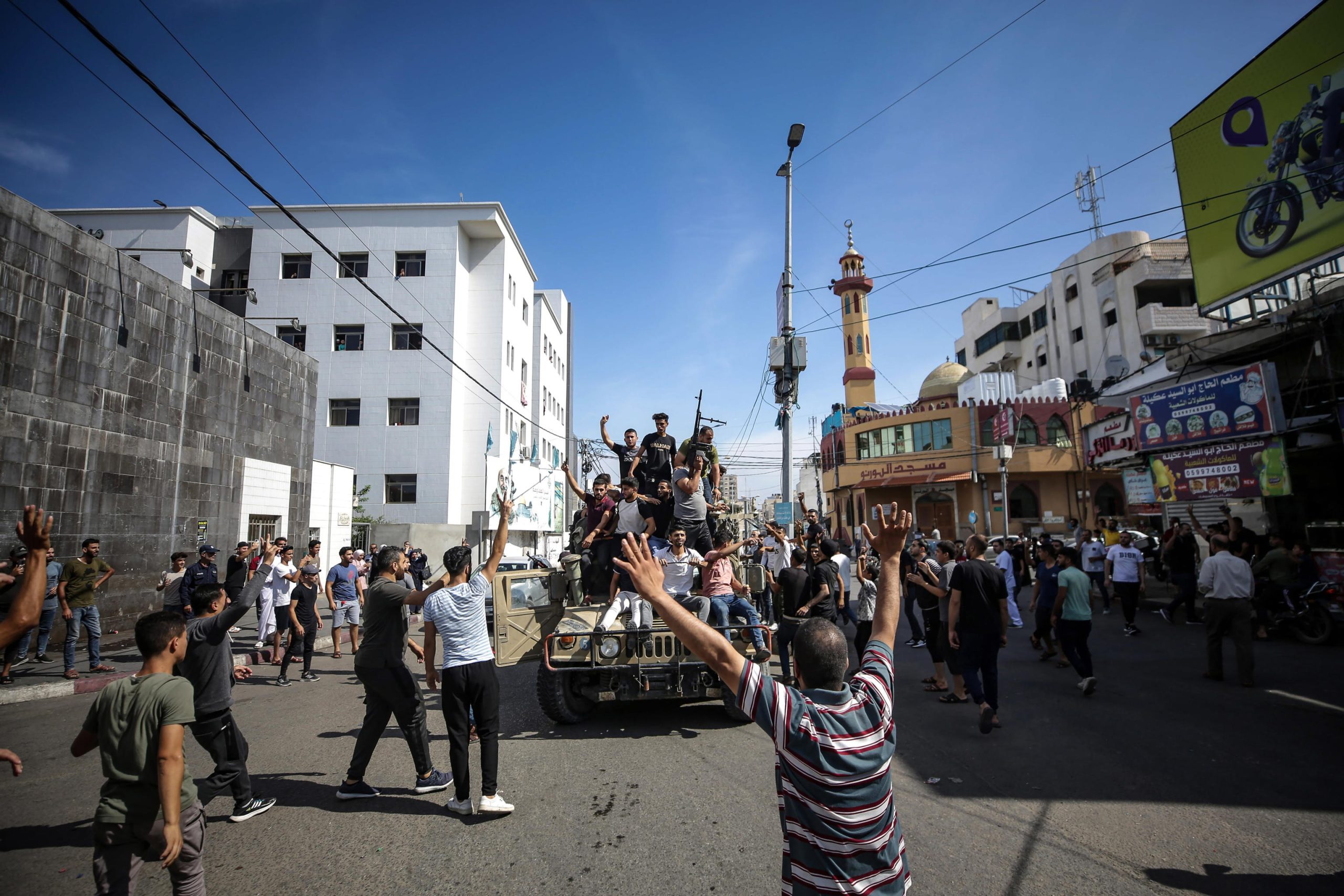 Miliziani palestinesi sfilano per le strade di Gaza a bordo di un veicolo militare israeliano catturato.