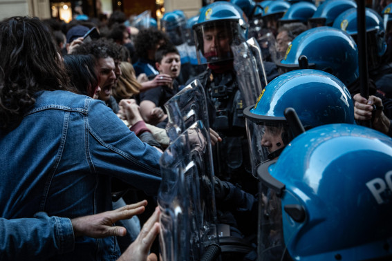 La polizia mentre respinge i manifestanti a colpi di scudo in via Indipendenza a Bologna.