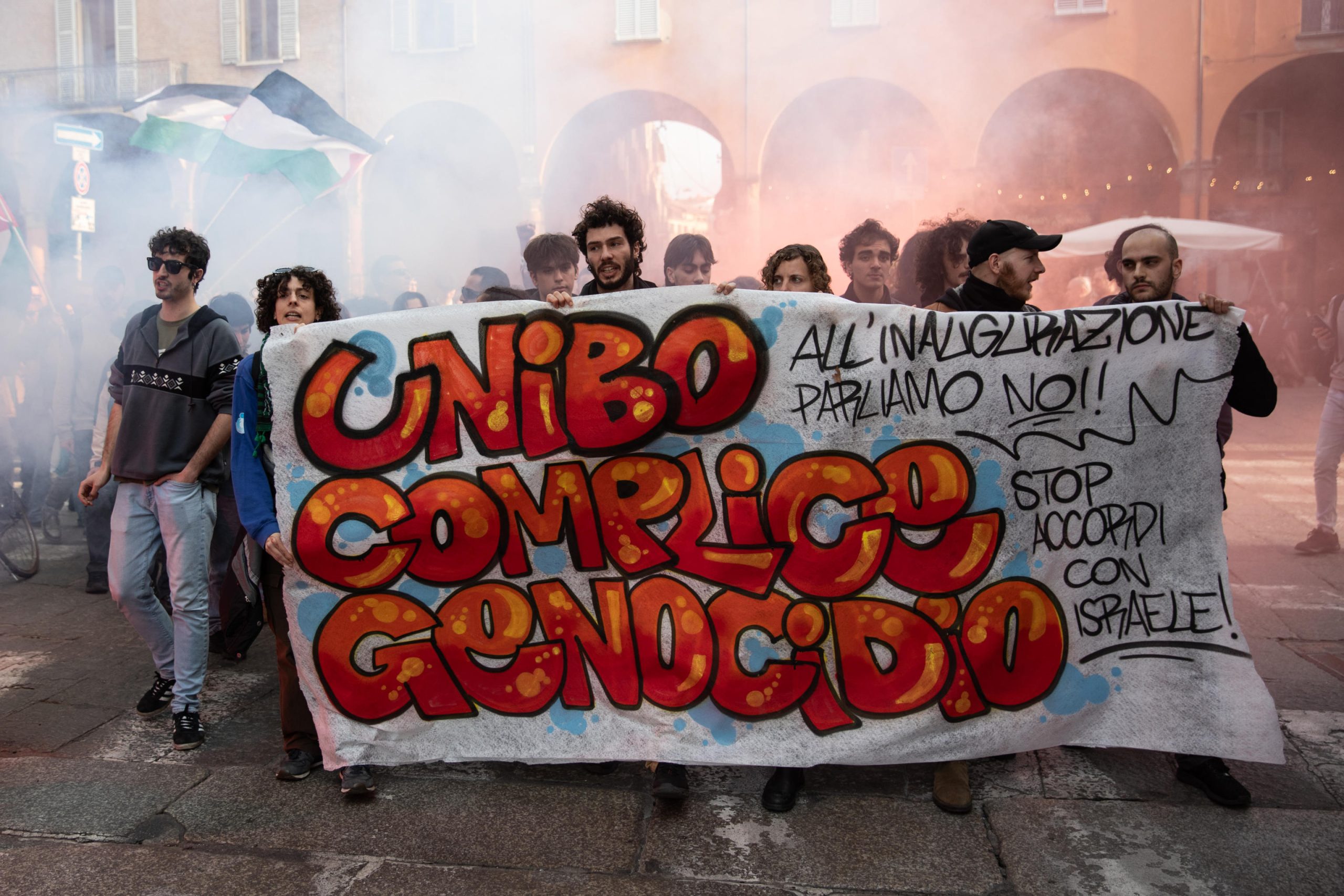 Il corteo dei collettivi mentre sventola uno striscione con scritto "Unibo complice del genocidio"