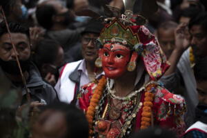 Un uomo nepalese indossa una maschera religiosa mentre partecipa alla manifestazione del Naradevi Dance festival a Kathmandu, in Nepal